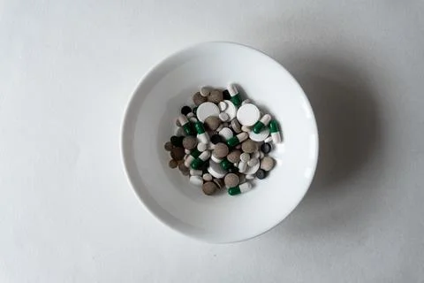 White plate with Different tablets and pills at white background Stock Photos