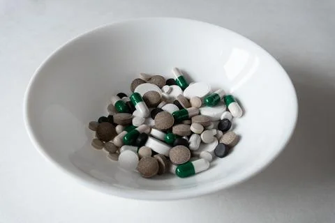 White plate with Different tablets and pills at white background Stock Photos