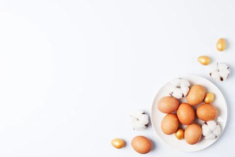 White plate with easter eggs and flowers on white background. Flat lay, copy  Stock Photos