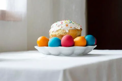White plate with a glazed easter cake and painted eggs on the table Stock-Fotos
