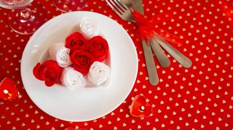 A white plate with a knife and fork on a bright red background Stockfoto's
