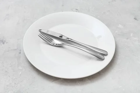 White plate with parallel knife, spoon on concrete food concept - white pl... 写真素材