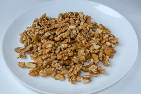 A white plate with peeled walnut kernel, close-up, top view, side view. Stock Photos