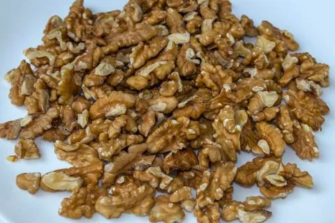 A white plate with peeled walnut kernel, close-up, top view, side view. Stock Photos