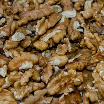 A white plate with peeled walnut kernel, close-up, top view, side view. Stock Photos