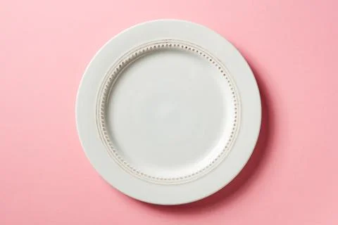 White plate on pink background, from above Stock Photos