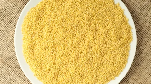 White plate with raw millet rotating Stock Footage 336464325
