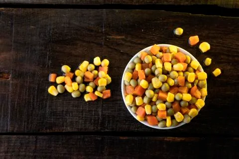 White plate on rustic table with vegetables. Stock Photos