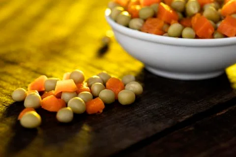 White plate on rustic table with vegetables. Stock Photos