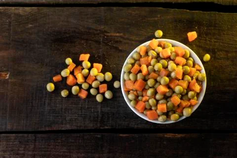 White plate on rustic table with vegetables. Stock Photos