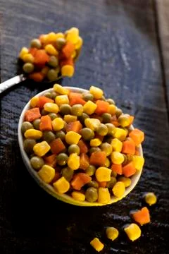 White plate on rustic table with vegetables. Stock Photos