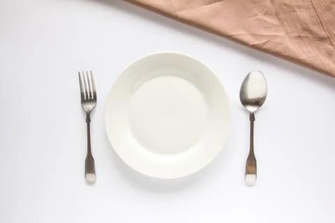 A white plate with silver fork and spoon Stock Photos