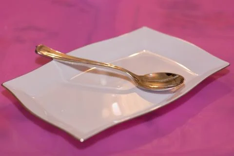 White plate with silver spoon Stock Photos