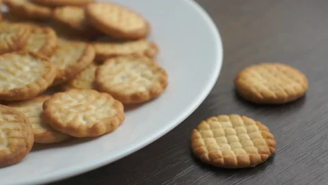 White plate with small round cookies is taken from table and put back Stock-Footage 152829861