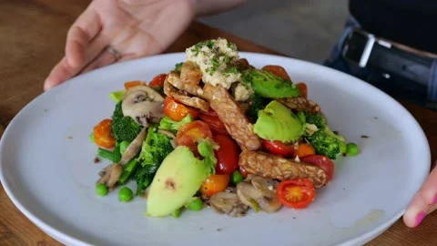 On a white plate, top view, there is a portion of fresh salad of vegetables Stock Footage 205588360