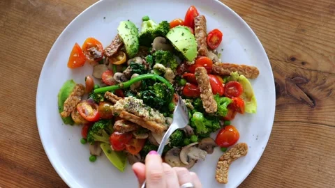 On a white plate, top view, there is a portion of fresh salad of vegetables Video stock 205588539