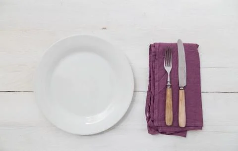 White plates and silverware on a light wood Stock Photos