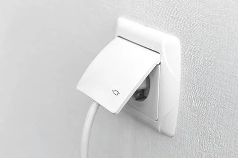 White plug into electric socket, modern interior photo Stock Photos