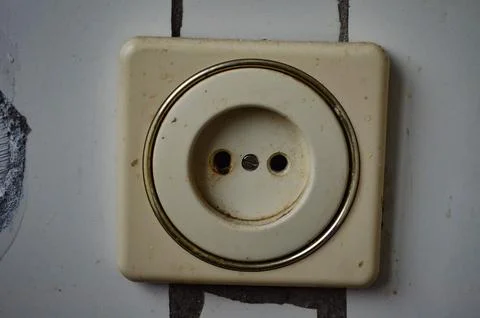 A white plug with a gold ring around it.  Stock Photos