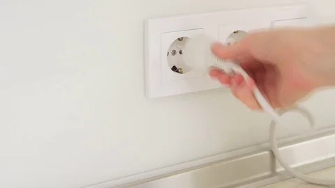 White plug in a wall socket rapid video Stock Footage 74407161