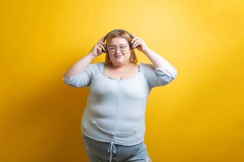 White Plus Size Model Wearing Headphones on Isolated Background Photos