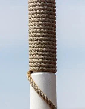 A white pole with a rope wrapped around it Stock Photos