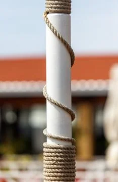 A white pole with a rope wrapped around it Stock Photos