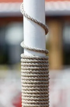 A white pole with a rope wrapped around it Stock Photos