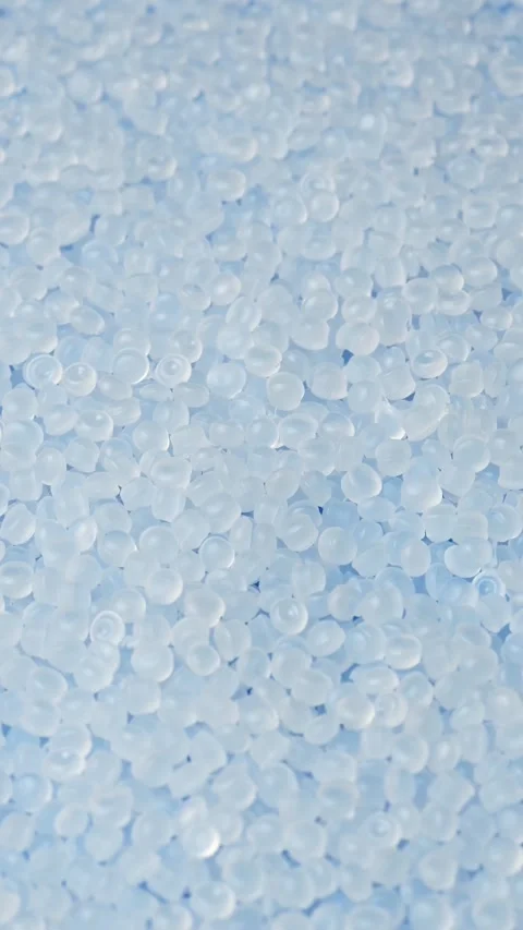 White polyethylene pellets rotate in soft focus for medical, packaging and Stock Footage 347048484