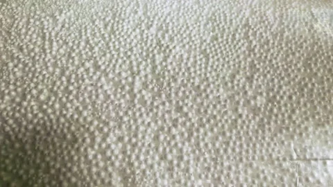 White polystyrene foam beads ball drop from Styrofoam machine for fragile stuff  Stock Footage 145714302