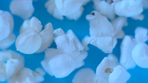 White popcorn on a blue background. Macro video of popcorn Stock Footage 124257624