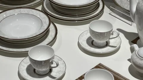White porcelain dinnerware set with elegant pattern displayed on table Stock Footage 312903427