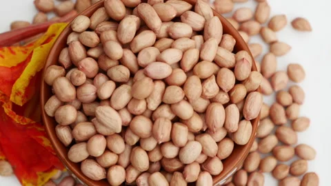 A white pot with a portion of peanuts, rotating, clear round bottom. Video stock 139745962