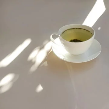 White pot of tea. Light background. Sun rays. Health, atmosphere, peaceful Stock Photos