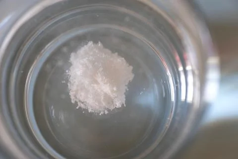White powder dissolving in clear water glass Stock-Fotos