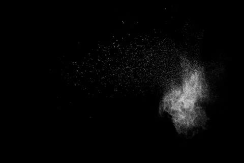 White powder explosion cloud against black background.White dust particles sp Stock Photos