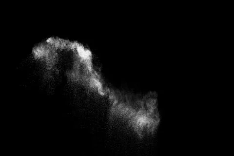 White powder explosion cloud against black background.White dust particles. Stock Photos