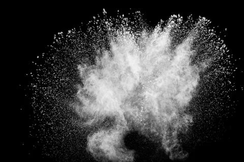 White powder explosion cloud against black background.White dust particles. Stock Photos