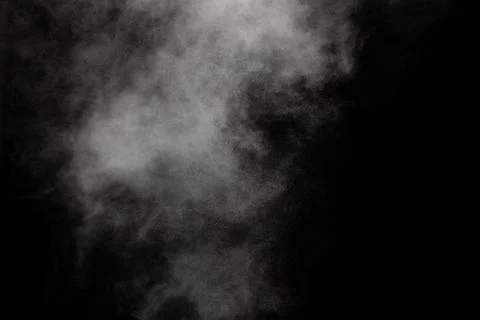 White powder explosion cloud against black background.White dust particle. Stock Photos
