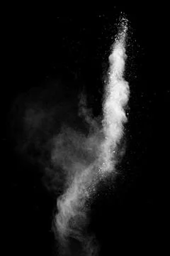 White powder explosion cloud against black background.White dust particle. Stock Photos