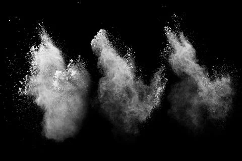 White powder explosion cloud against black background.White dust particle. Stock Photos