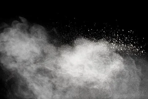 White powder explosion cloud against black background.White dust particle. Stock Photos