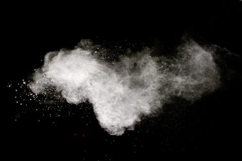White powder explosion cloud against black background.White dust particle. Stock Photos