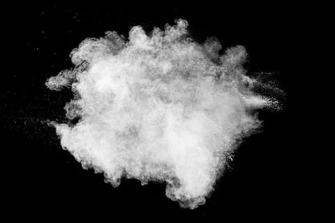 White powder explosion cloud against black background. White dust particle. Stock Photos