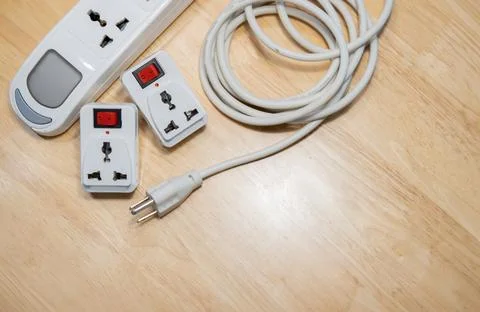 White power extension lead with multiple sockets on wooden table. Stock Photos
