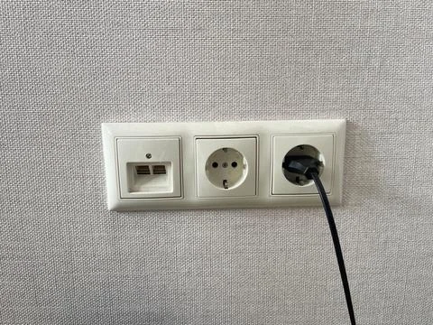 White power socket with black cable on white background. Copy space. Stock Photos