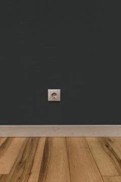 White power socket in wall over wooden floor Stock Photos