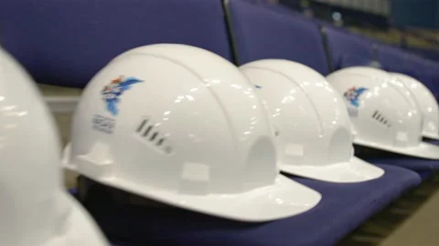 White protective hardhats on seats at modern stadium Stock Footage 236708316