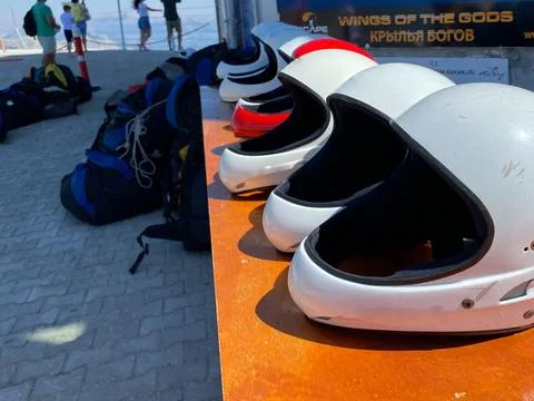 White protective helmets for extreme skydiving lie on the table Stock Photos