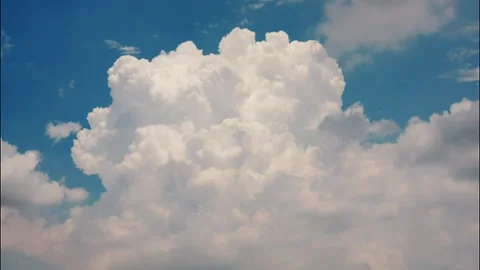 White puffy clouds drifting across a bright blue sky during a sunny afternoon Stock Footage 340902293